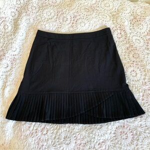 The limited black pleaded asymmetrical miniskirt
